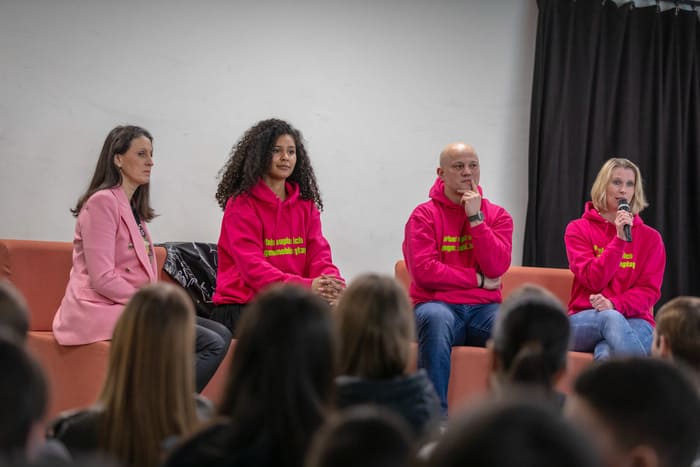 Lijana Kaggwa sitzt in einem Panel mit weiteren Gaesten bei einer Veranstaltung zur Cybermobbing-Praevention.